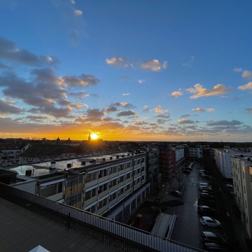 Das Bild zeigt einen Sonnenaufgang über den Dächern von Bernau bei Berlin.