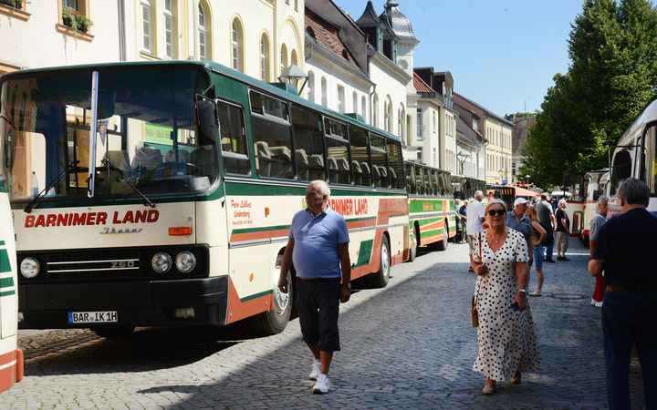 Historische Busse stehen in der Fußgängerzone. 