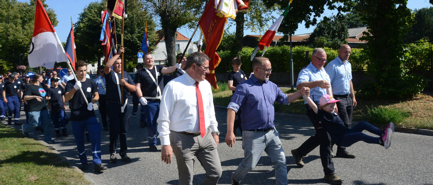 Feuerwehrfestumzug angefügrt von 4 Personen. 