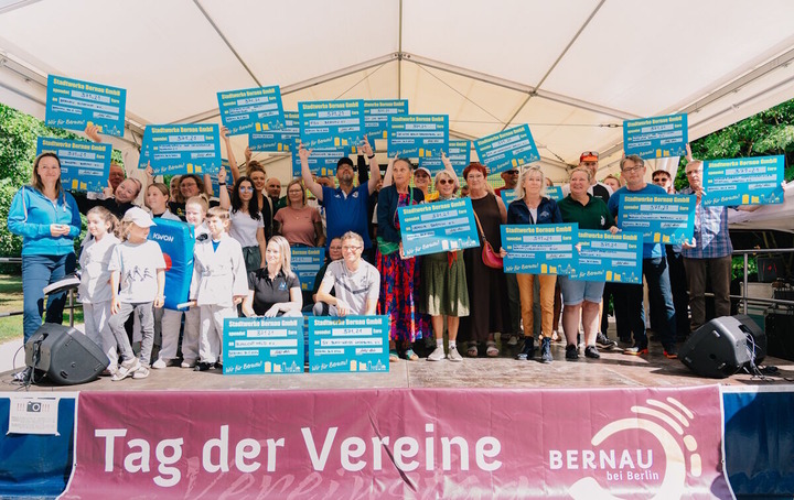 Man sieht auf dem Foto eine Gruppe Menschen, die von den Stadtwerken einen Spendenscheck bekommen haben