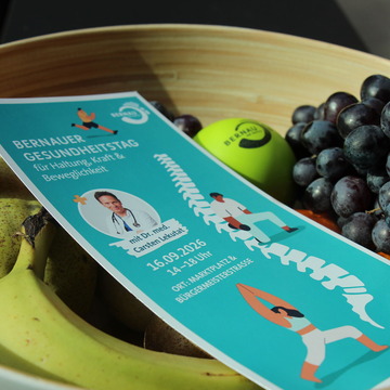 Eine Obstschale in der ein Flyer liegt. Darauf stehen die Infos zum Gesundheitstag 2026. 