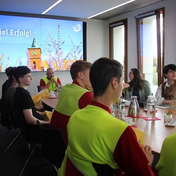 Das Bild zeigt die neuen Auszubildenen im Gespräch am Tisch 