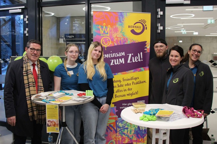 Am Messestand der Stadt Bernau stehen verschiedene Vertretende der Stadt und lächeln. 
