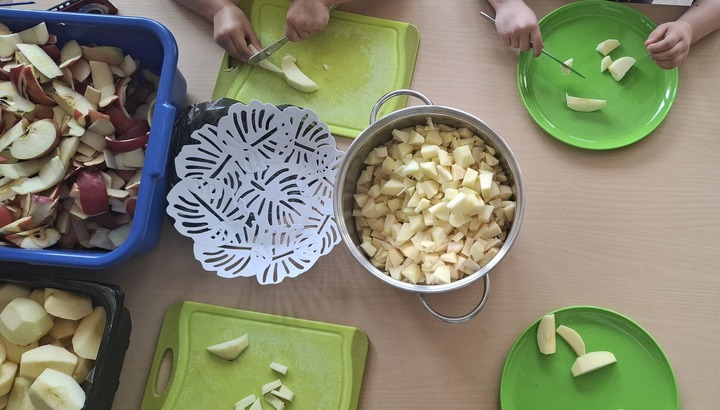 Kinderhänge schneiden Äpfel klein.