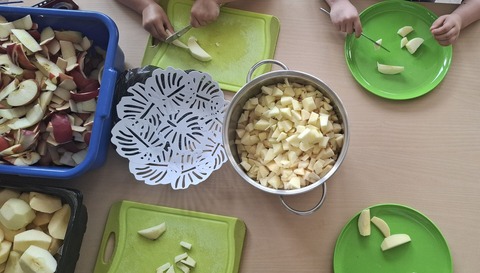 Kinderhänge schneiden Äpfel klein.