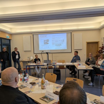 Runde Blickt auf Power Point Prsentation, Bürgermeister André Stahl spricht am Mikro 