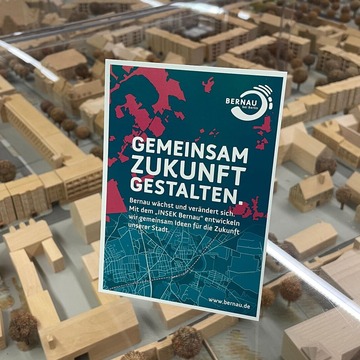 Die Postkarte des Projekst INSEK steht auf einem Schaukasten mit einem Stadtmodell der Stadt Bernau.