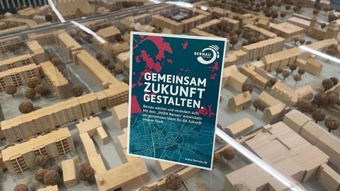 Die Postkarte des Projekst INSEK steht auf einem Schaukasten mit einem Stadtmodell der Stadt Bernau.
