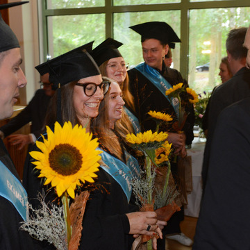 Die Absolvenztinnen und Absolventen erhielten Sonnenblumen und ihre Zuegnisse. 