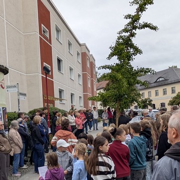 Das Bild zeigt die Menschen, welche sich die Verlegung der Stolpersteine anschauen