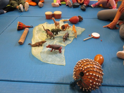 Das Bild zeigt verschiedene Instrumente und Spielfiguren von Tieren aus Afrika