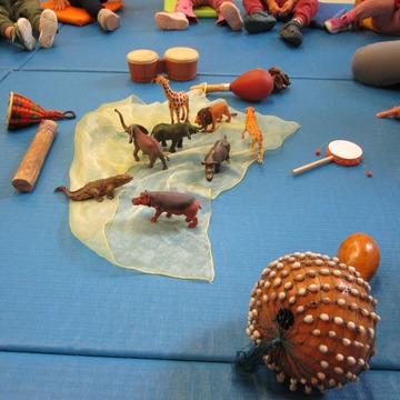 Das Bild zeigt verschiedene Instrumente und Spielfiguren von Tieren aus Afrika
