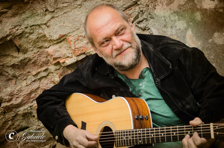Das Bild zeigt den Musiker Uli Kirsch mit seiner Gitarre