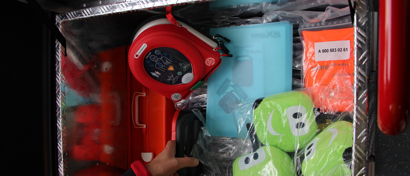 Inhalt der Box im inneren des Fahzeugs, darin Dafibirlator, Wärmedcken, Getränke und Kuscheltier. 